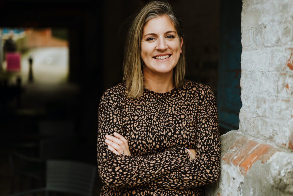 Emily Braithwaite from Yellow Tuxedo wearing a leopard print dress and leaning against a wall