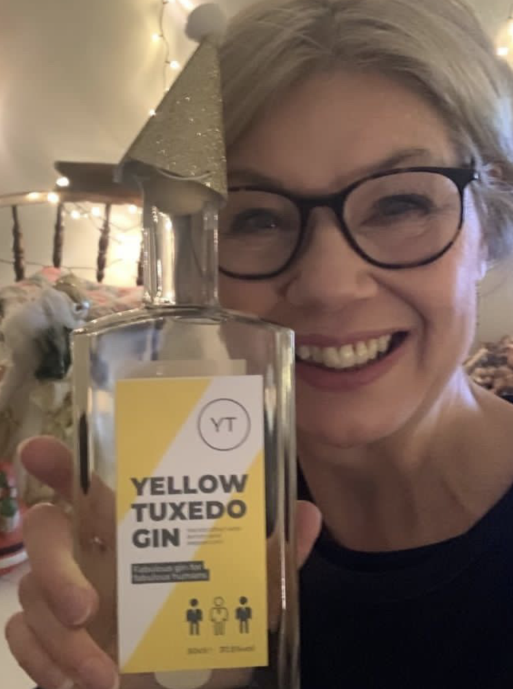 Jackie Goddard from Power to Speak holding a bottle of Yellow Tuxedo gin.